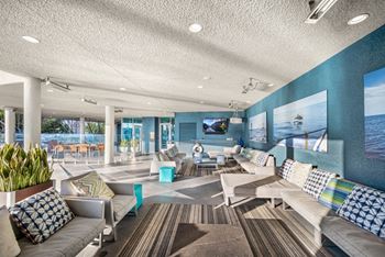 A living room with a couch, chairs, and a television.